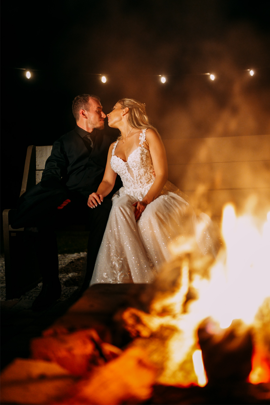 Bride and groom kissing in front of the fireplace at Ever After Farms Ranch wedding reception